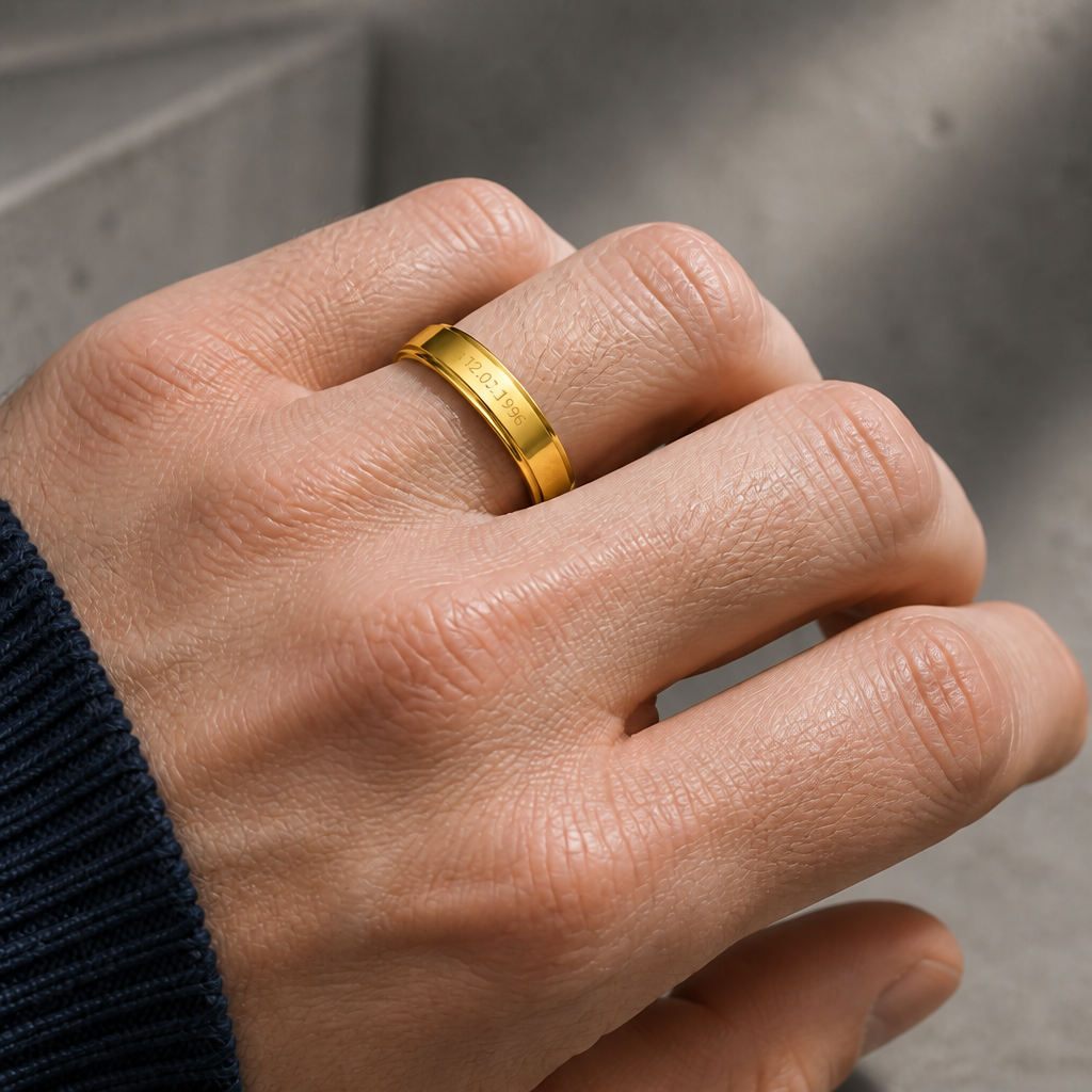 Bague gravée dorée portée à l'annulaire d'un homme