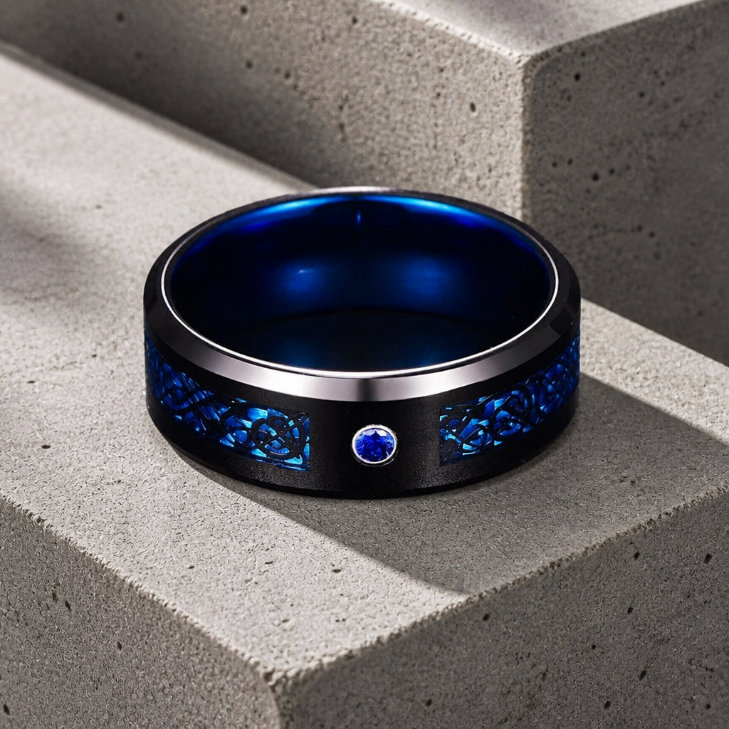 Bague bleu celtique homme en tungstène noir, motif celtique bleu et petite pierre bleue, posée sur béton