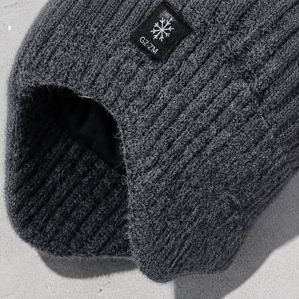 Détail du cache-oreille et de l'étiquette au flocon sur le bonnet gris foncé