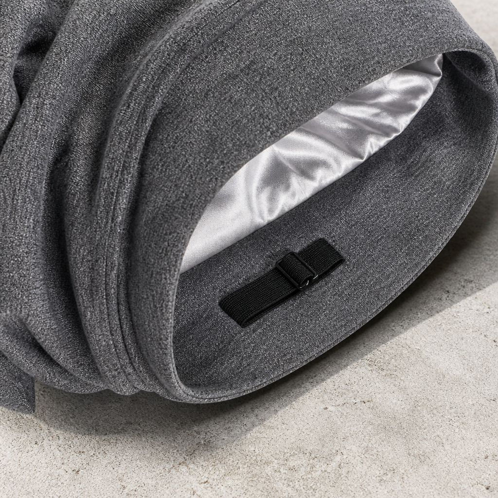 Gros plan sur la patte de réglage élastique et la doublure satinée du bonnet gris