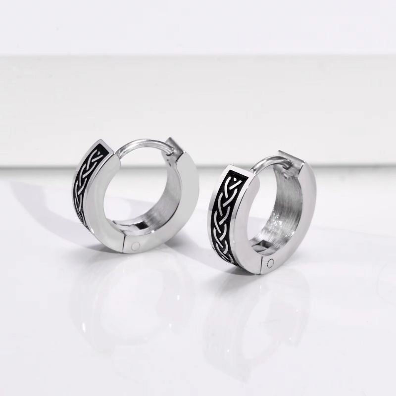 Boucles d’oreilles créoles viking en acier inoxydable avec gravure celtique, posées sur fond blanc