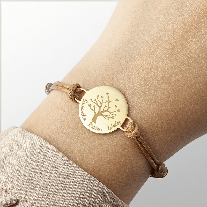 Bracelet arbre de vie porté au poignet, médaillon doré gravé de prénoms