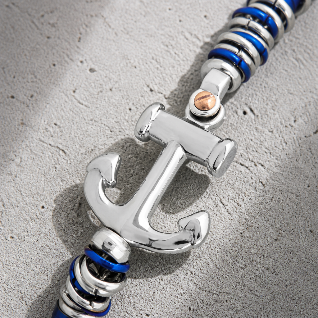 Ancre en acier au centre du bracelet bleu homme, macro sur les perles