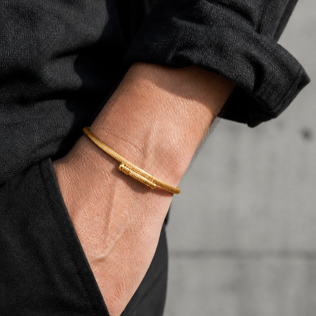 Bracelet câble torsadé or porté au poignet d'un homme