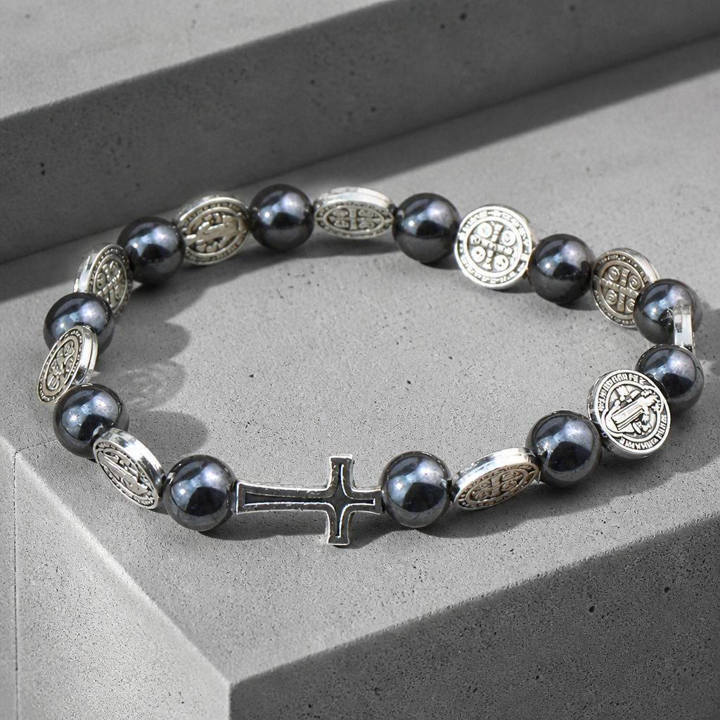 Le bracelet posé sur un rebord de béton, la croix argentée au premier plan