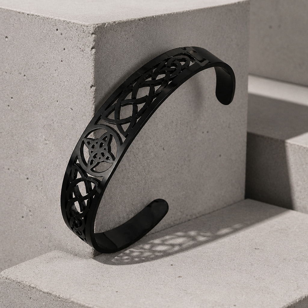 Bracelet celtique homme noir, jonc ouvert ajouré d'entrelacs, appuyé sur un bloc de béton