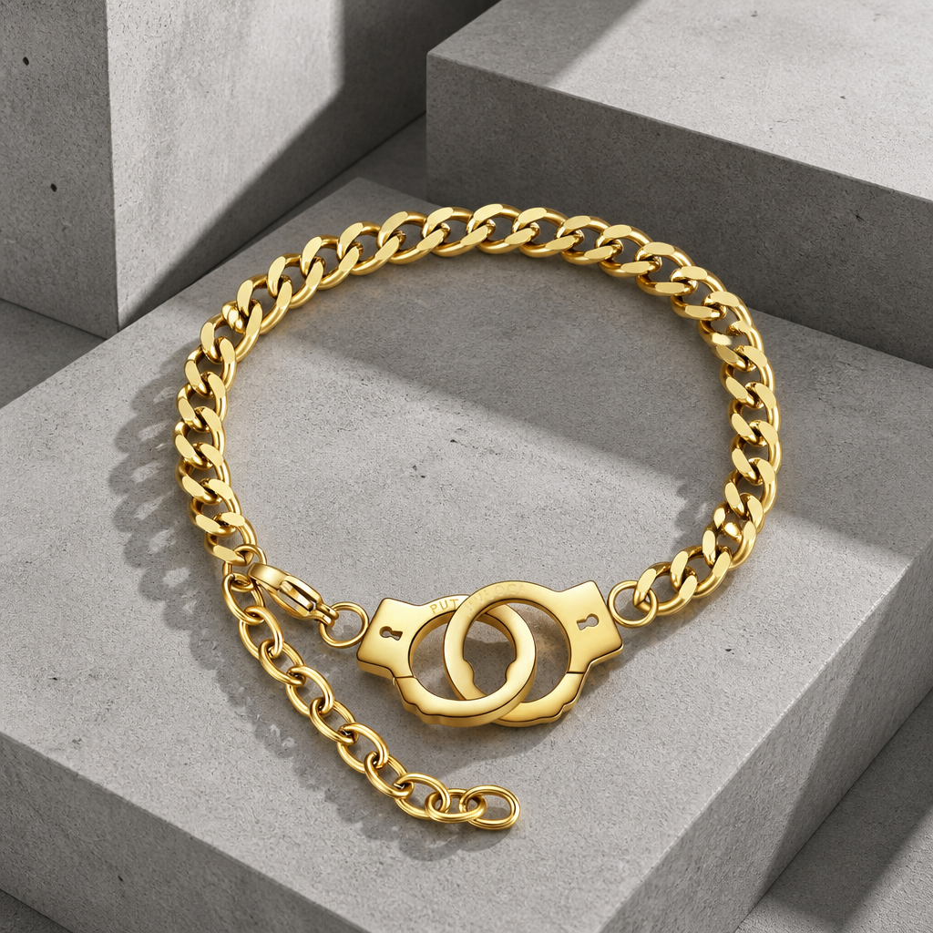 Bracelet chaîne acier homme finition orée, maille gourmette et fermoir menotte, sur béton