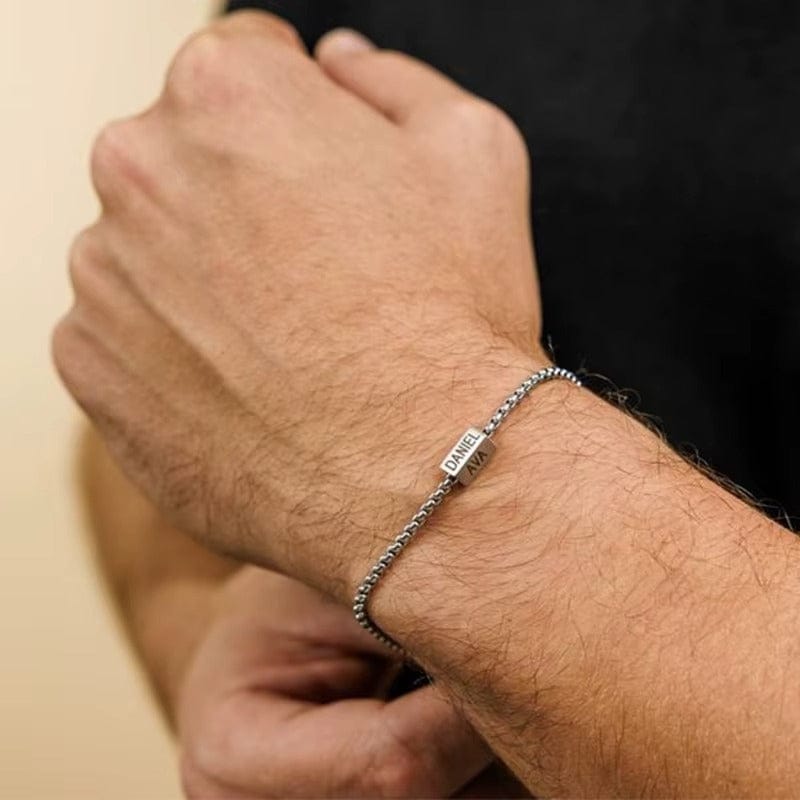 Bracelet chaîne homme argent porté au poignet, plaque gravée