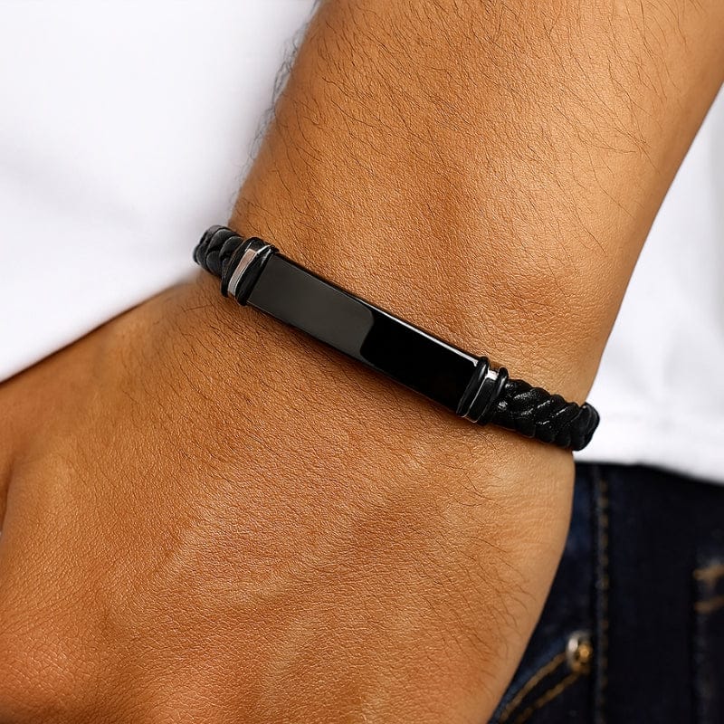 Bracelet homme gravé porté au poignet, plaque bombée noire sur cordon noir
