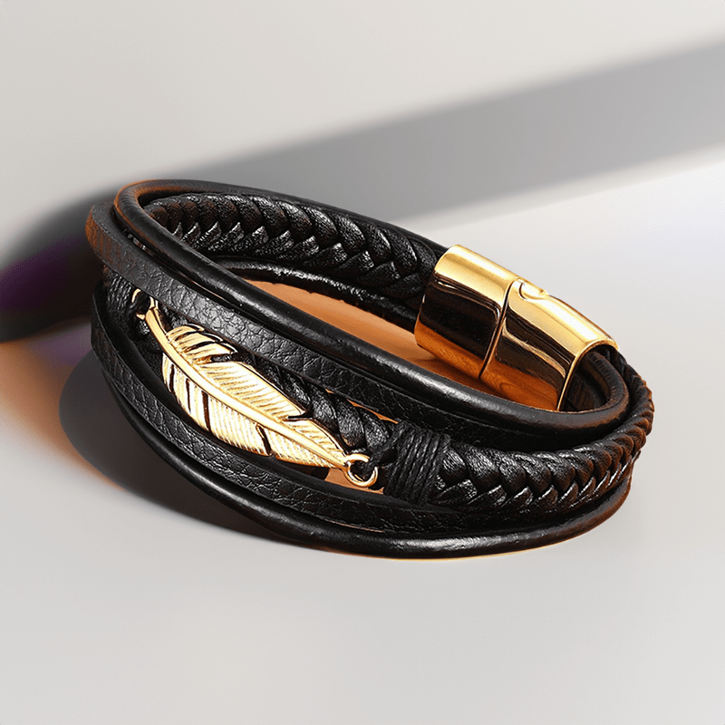 Bracelet cuir et plume en acier posé à plat