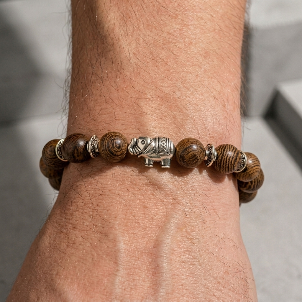 Bracelet de perles de bois porté au poignet, éléphant argenté au centre