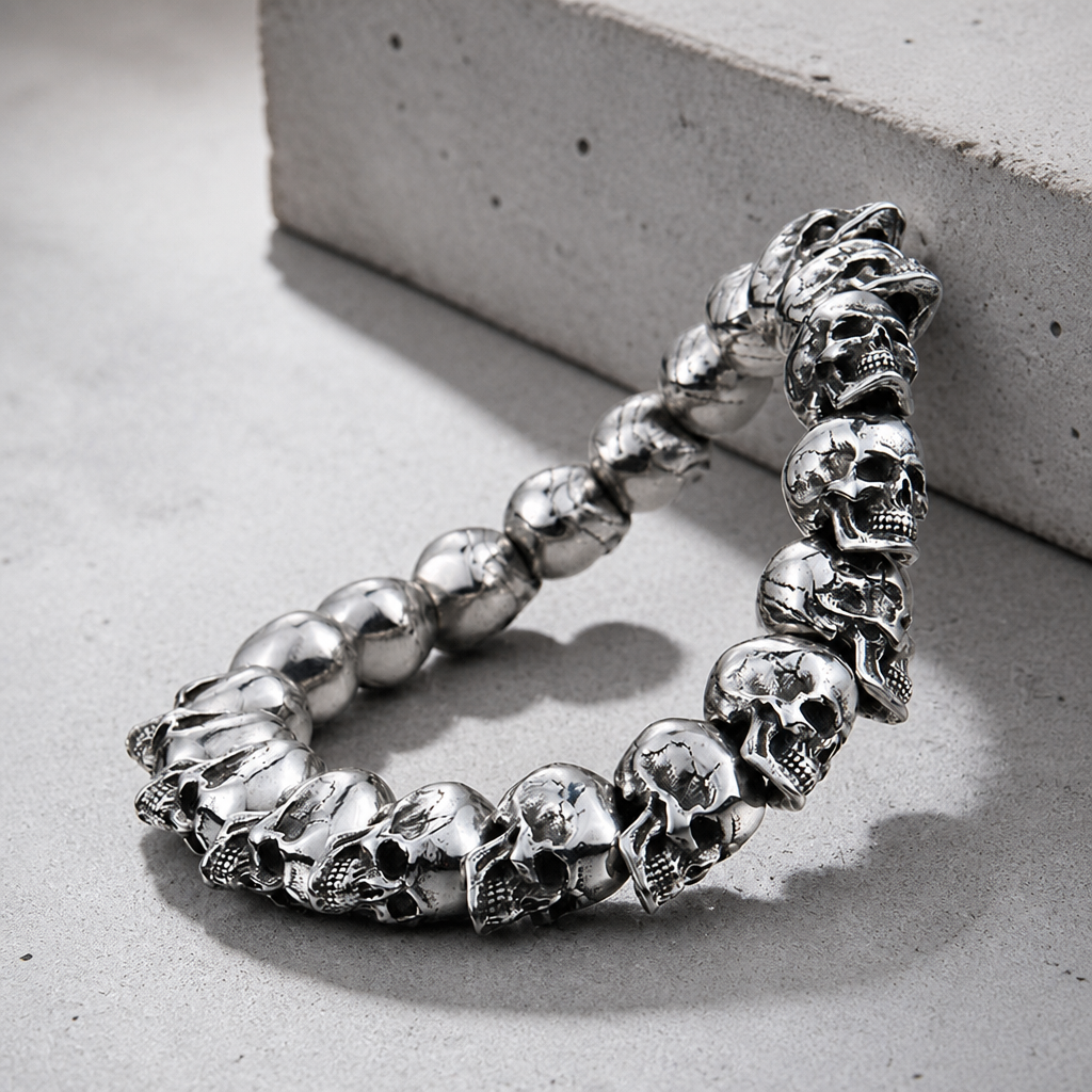 Rang de têtes de mort du bracelet gothique homme, vue de trois quarts sur béton
