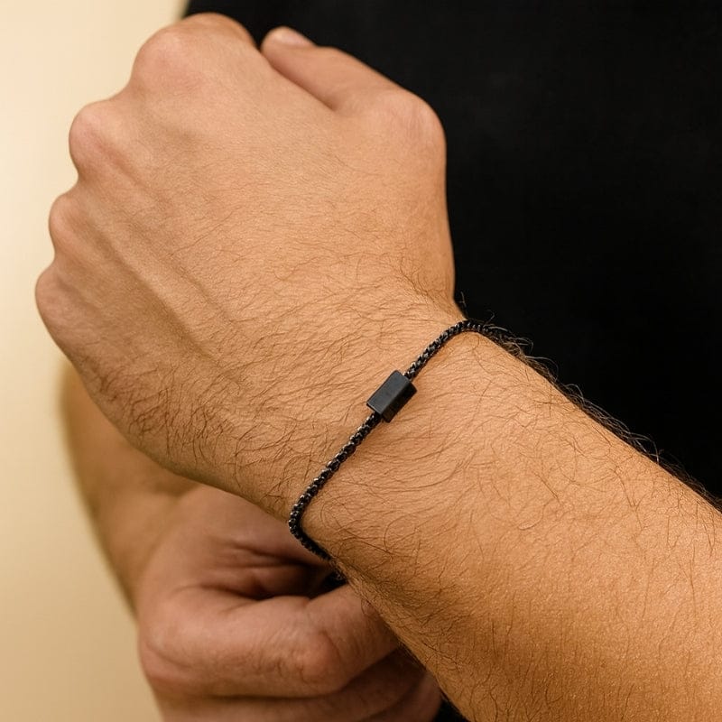 Bracelet homme chaîne fine noire portée au poignet