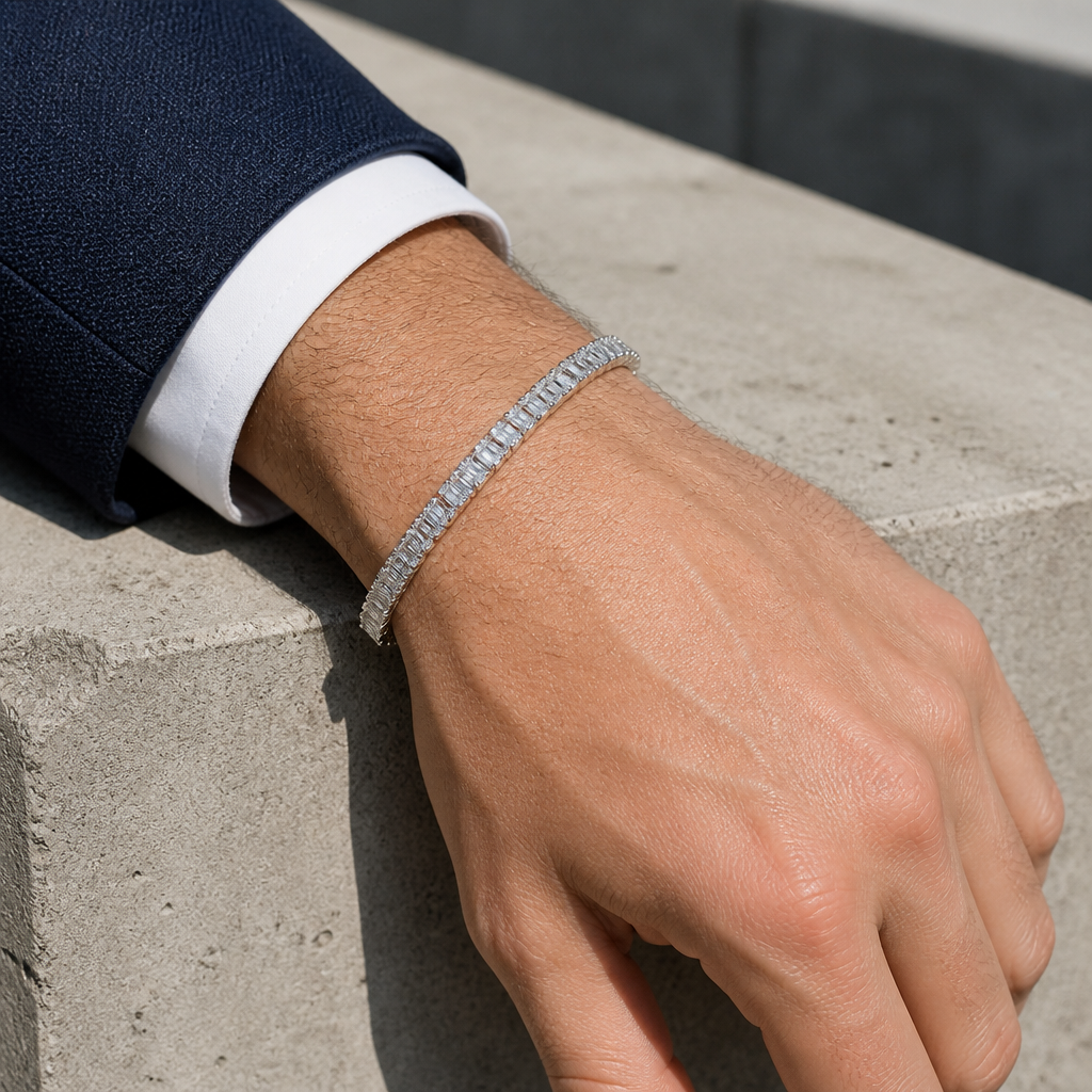 Bracelet argenté porté avec une veste, avant-bras posé sur du béton