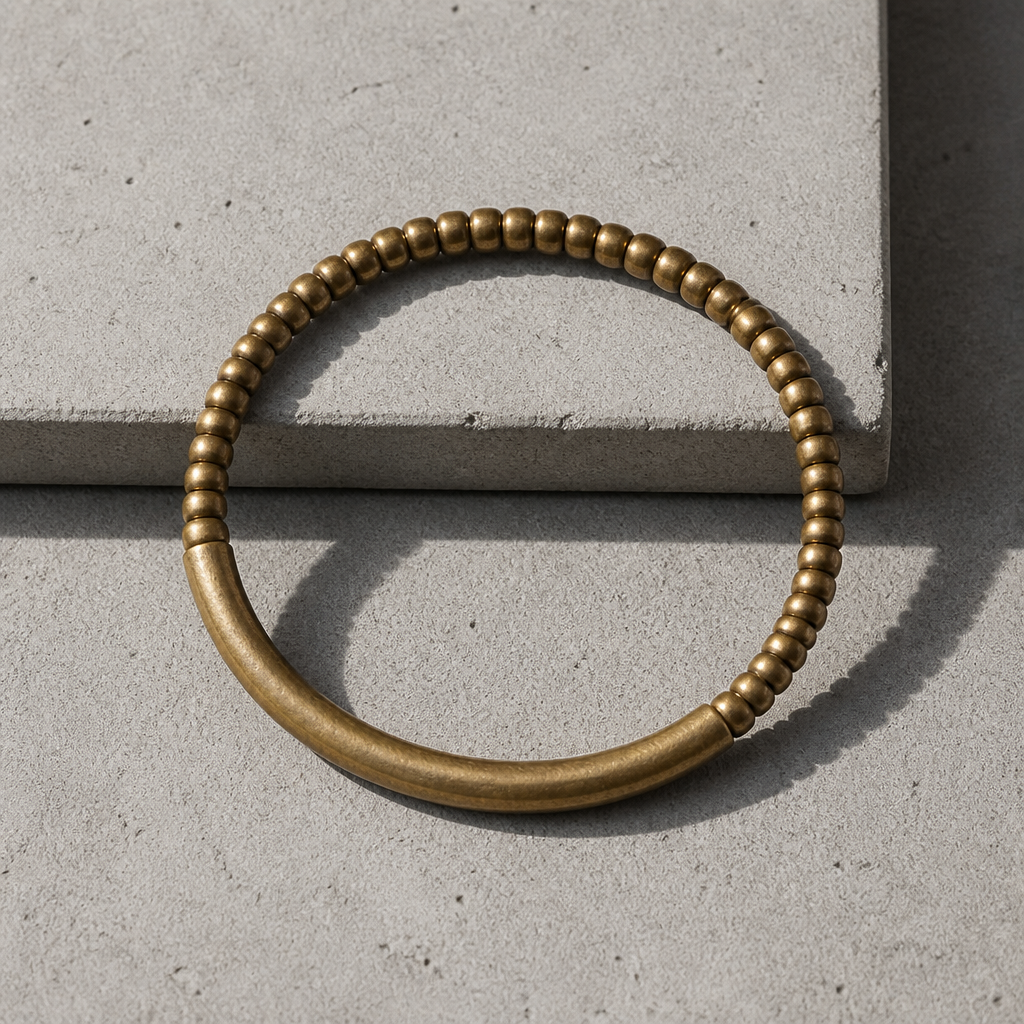 Bracelet homme en laiton vu de dessus, perles plates et tube incurvé