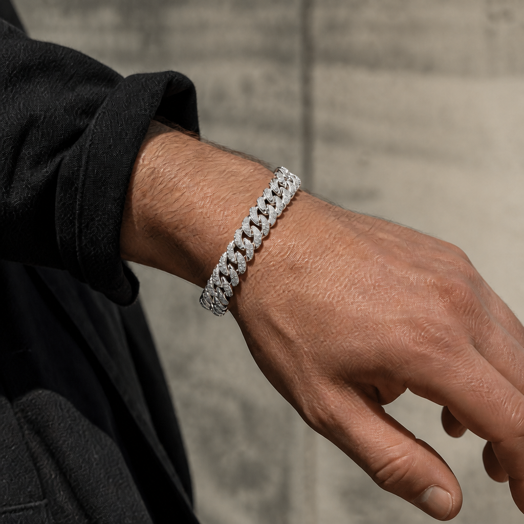Maille cubaine double rang argentée portée au poignet, sous une manche sombre