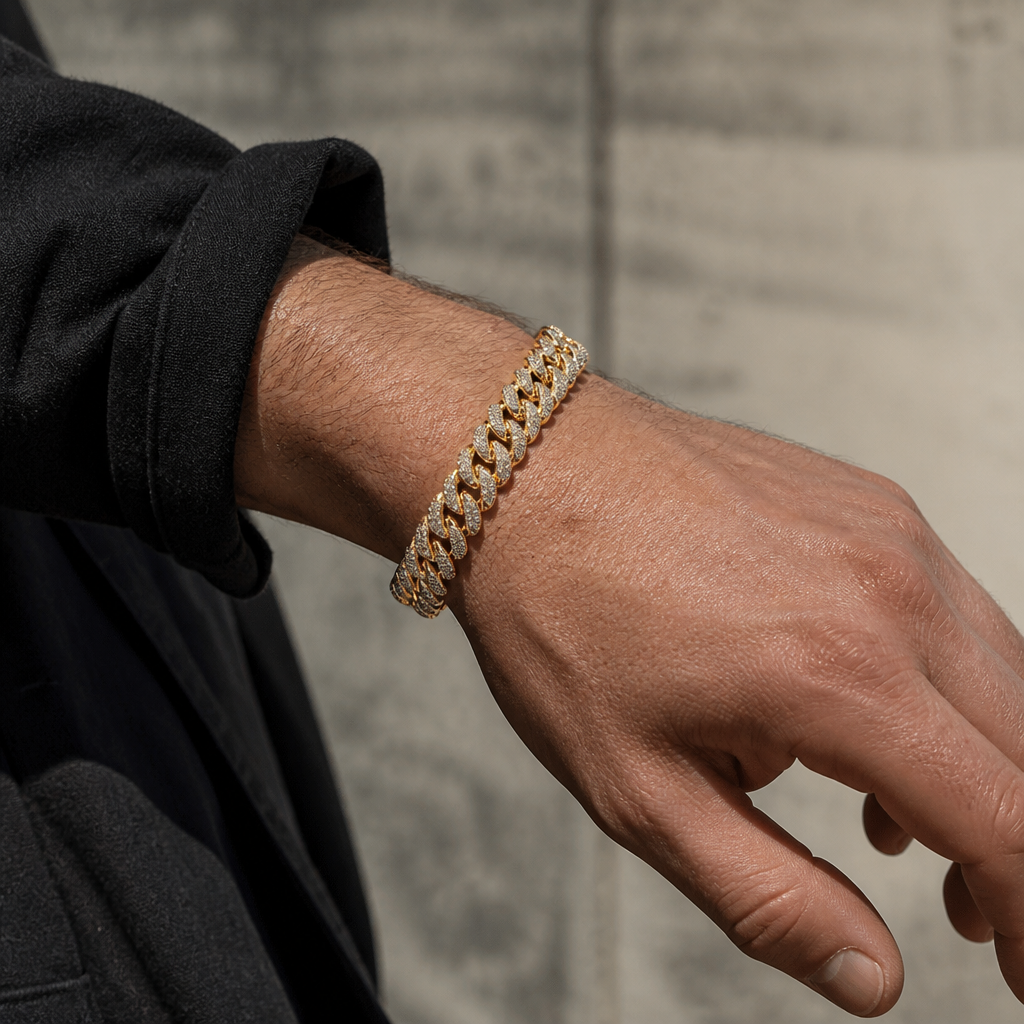 Maille cubaine double rang dorée portée au poignet, sous une manche sombre