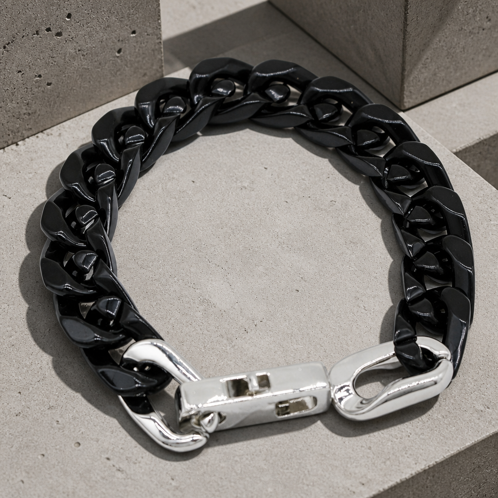 Bracelet homme en maille cubaine laquée noire, packshot sur béton clair
