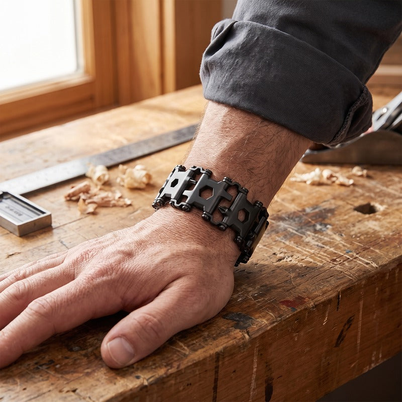 Bracelet homme outil noir porté au poignet sur un établi d'atelier