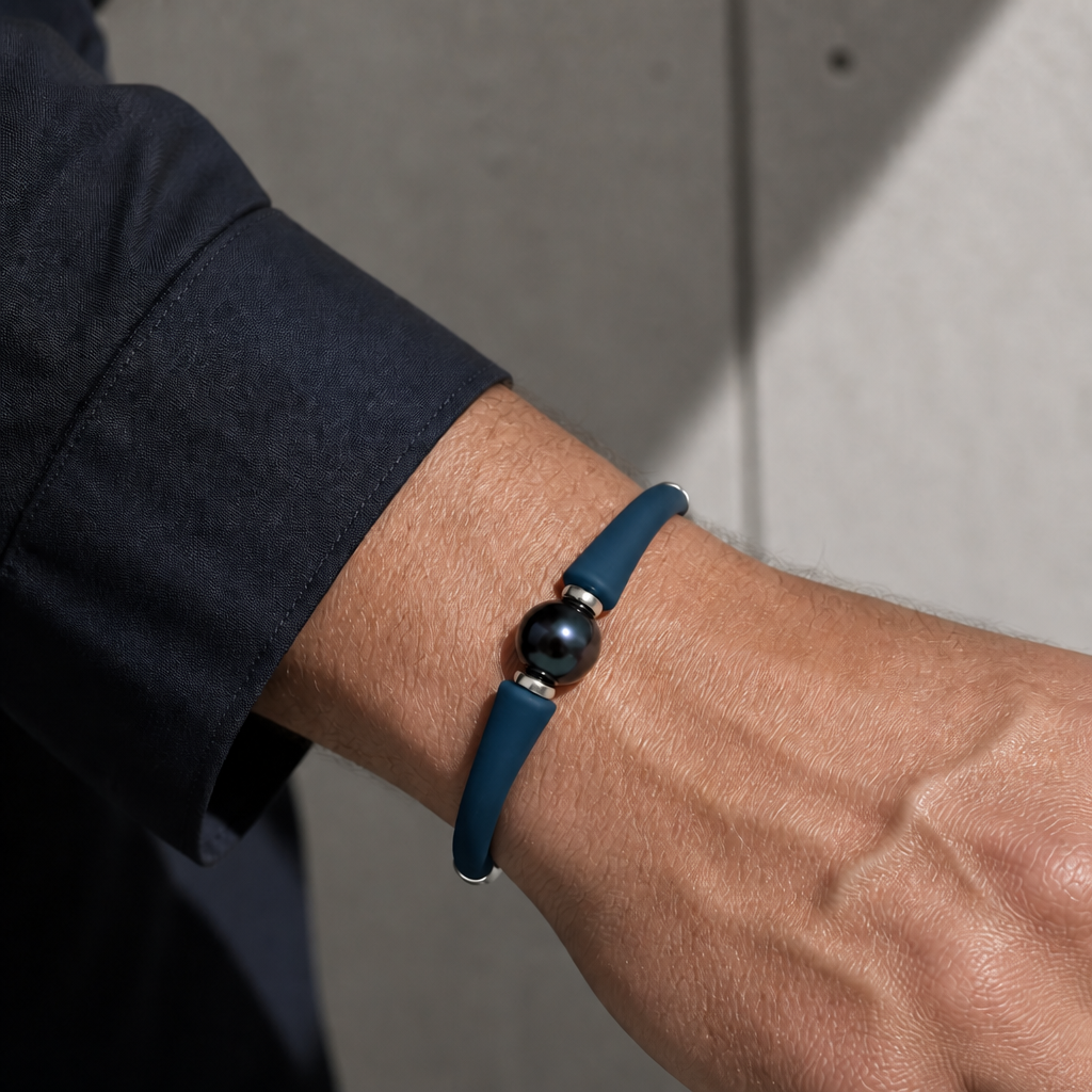 Bracelet perle de culture sur jonc bleu porté au poignet d'un homme