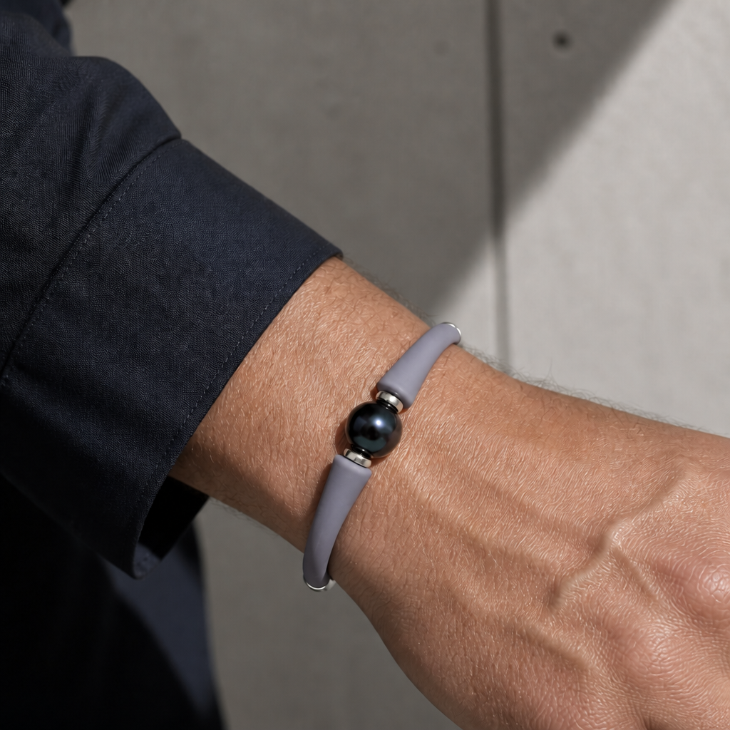 Bracelet perle de culture sur jonc gris porté au poignet d'un homme