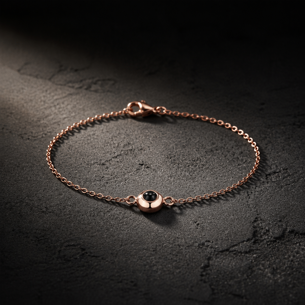 Bracelet photo chaîne fine finition or rose sur béton sombre
