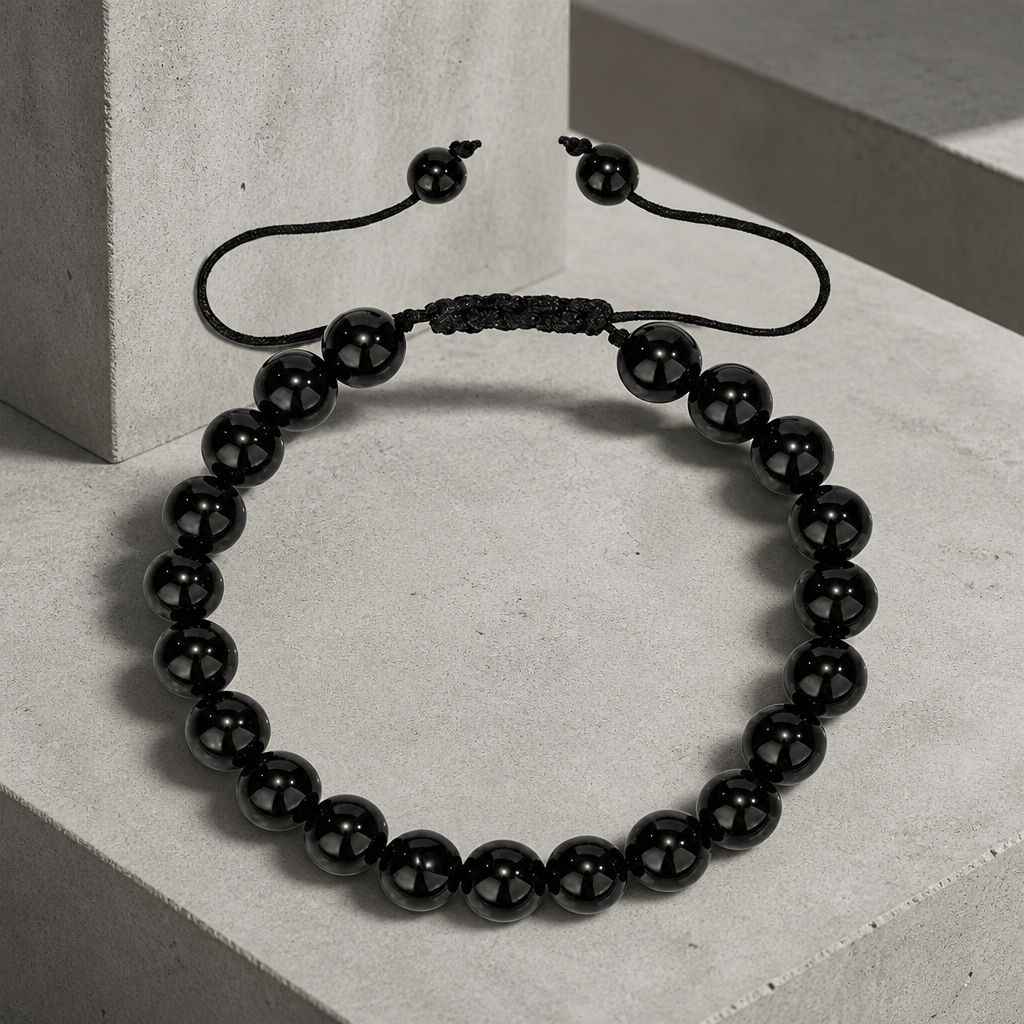 Bracelet homme en agate noire, cordon tressé ajustable, sur béton