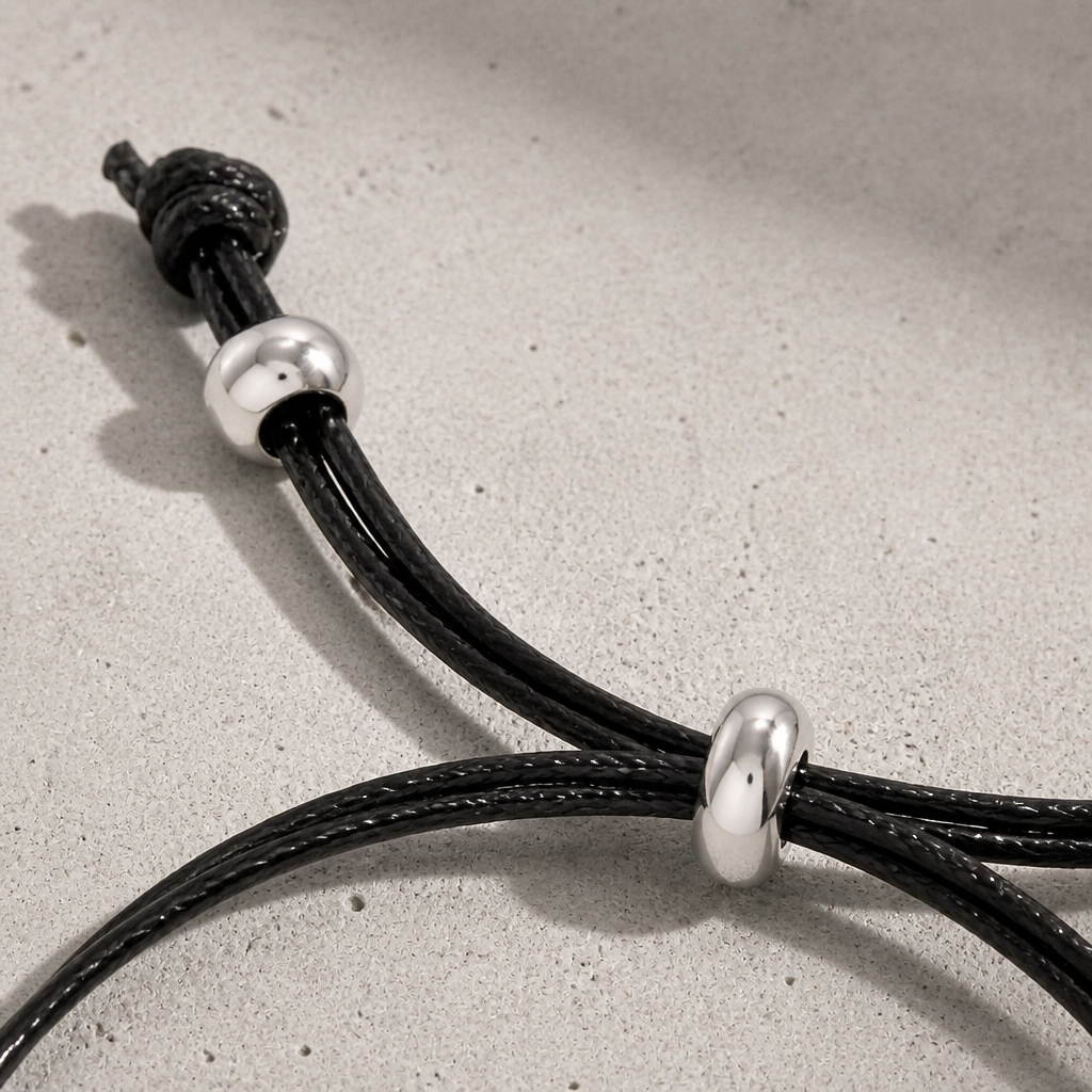 Détail du nœud coulissant réglable et des perles acier du bracelet cordon
