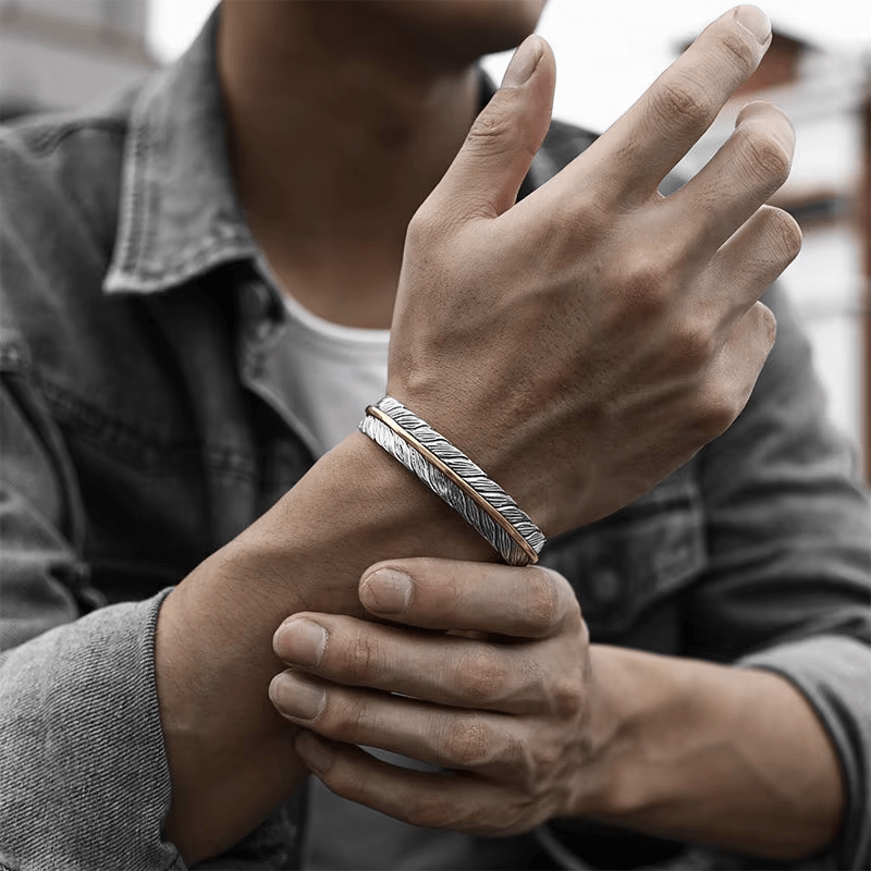 Bracelet plume homme porté au poignet avec une veste en jean