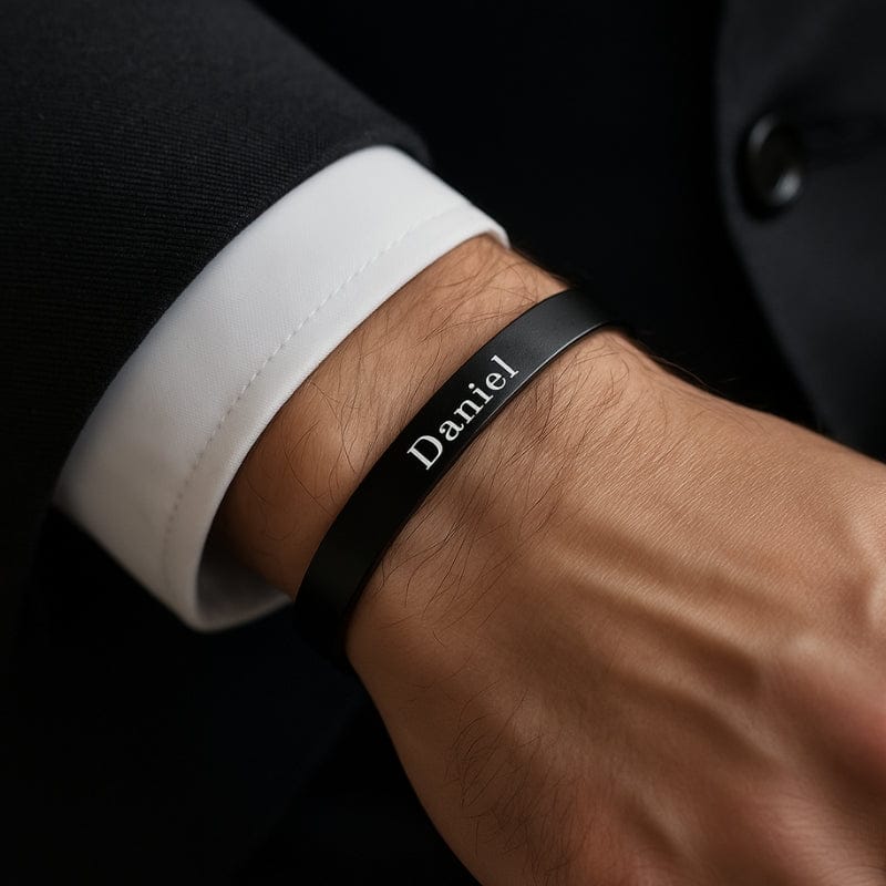 Bracelet jonc homme noir porté au poignet avec une chemise blanche