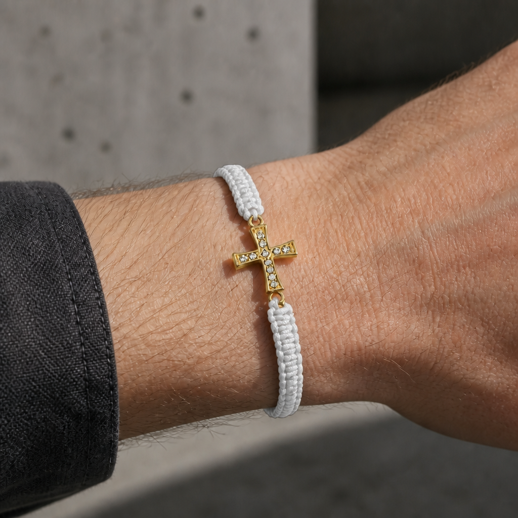 Bracelet macramé blanc à croix dorée porté au poignet