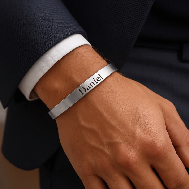 Bracelet minimaliste homme porté au poignet, jonc en acier poli gravé