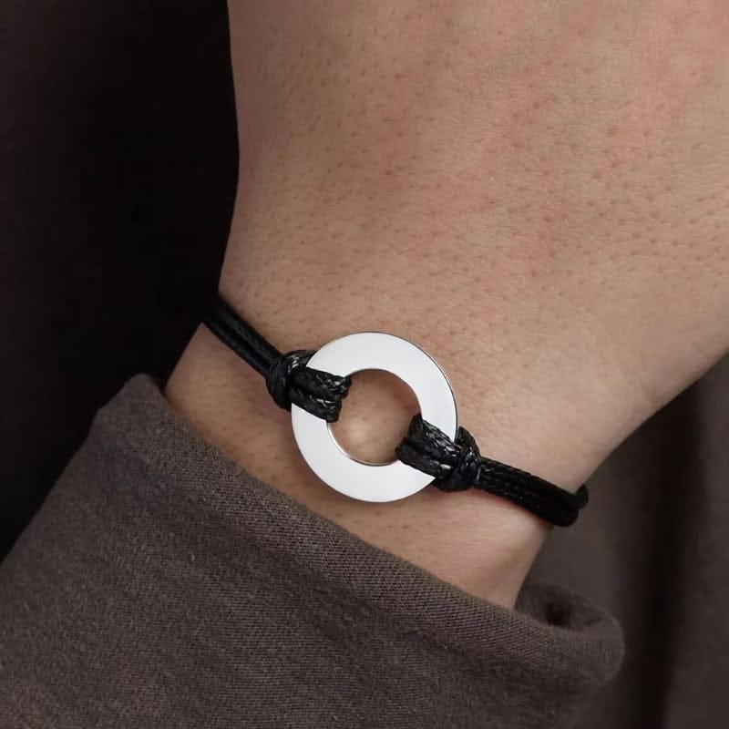 Bracelet homme ajustable en cordon noir et anneau d'acier, porté au poignet