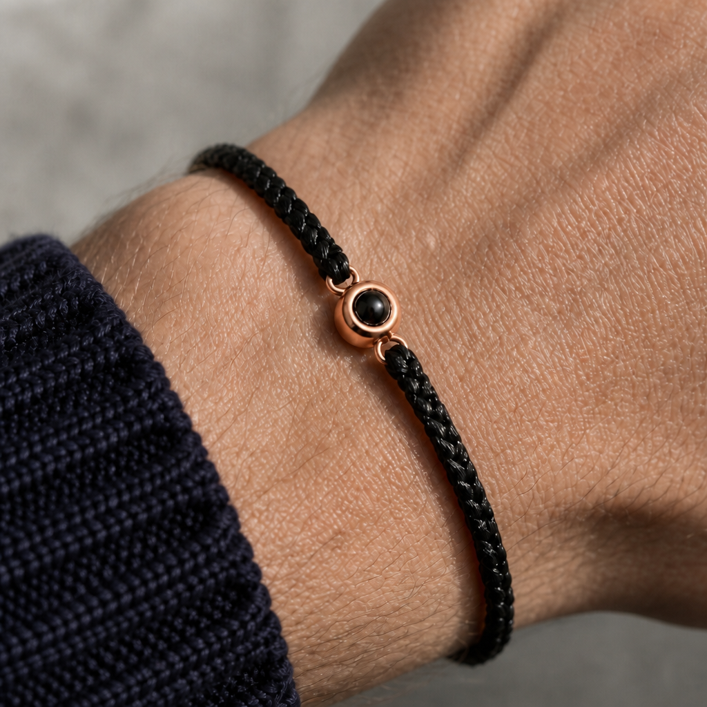 Bracelet photo personnalisé porté au poignet, cordon tressé noir et perle or rose
