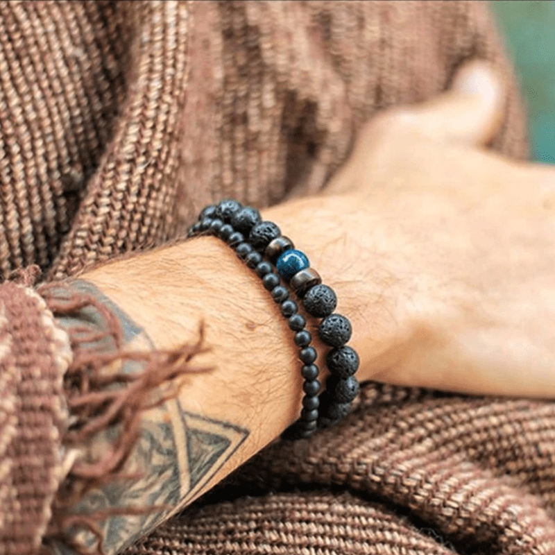 Bracelet homme pierre de lave porté au poignet avec un pull en laine