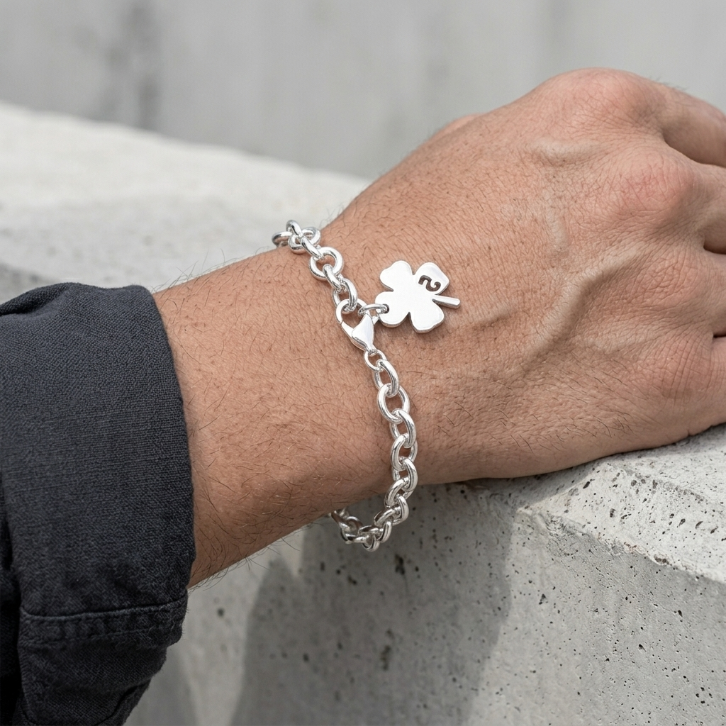 Bracelet trèfle argenté porté, avant-bras posé sur un bloc de béton