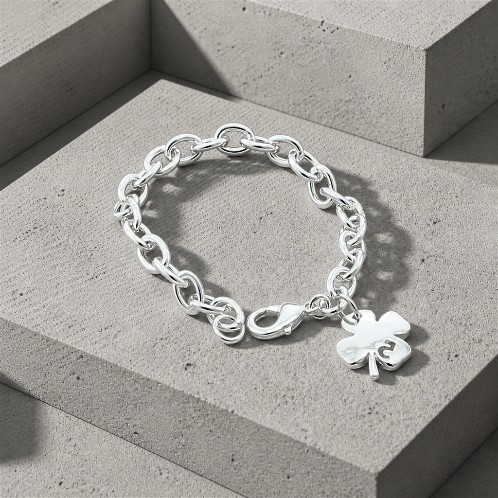 Bracelet trèfle argenté à maillons ovales, vue de trois quarts sur béton