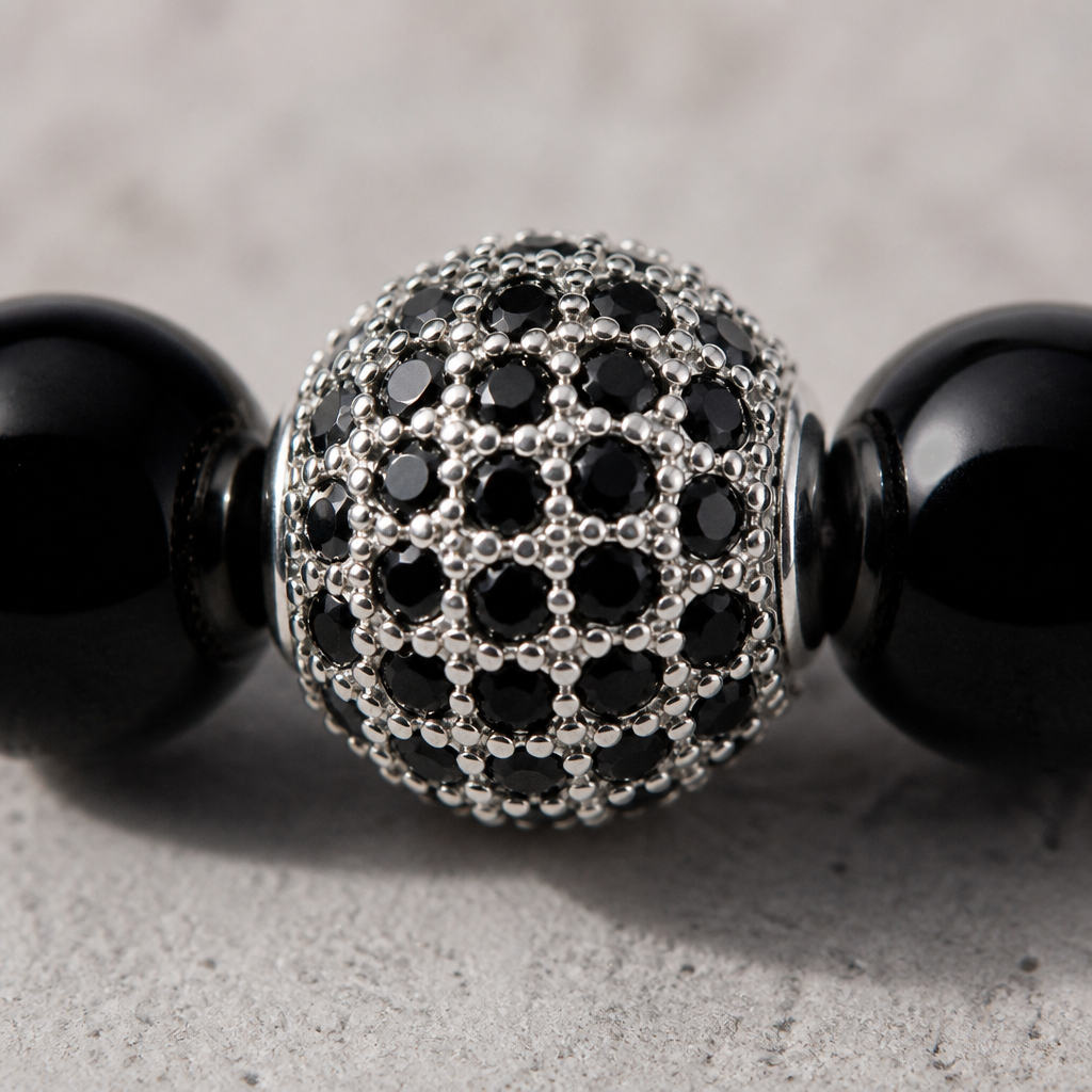 Macro de la bille pavée argentée sertie de micro-pierres noires en griffes