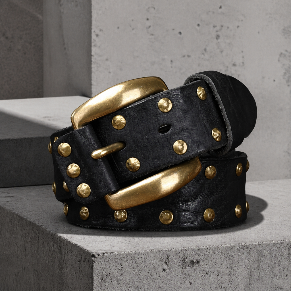 Détail des rivets dorés et de la boucle fer à cheval en laiton sur le cuir noir