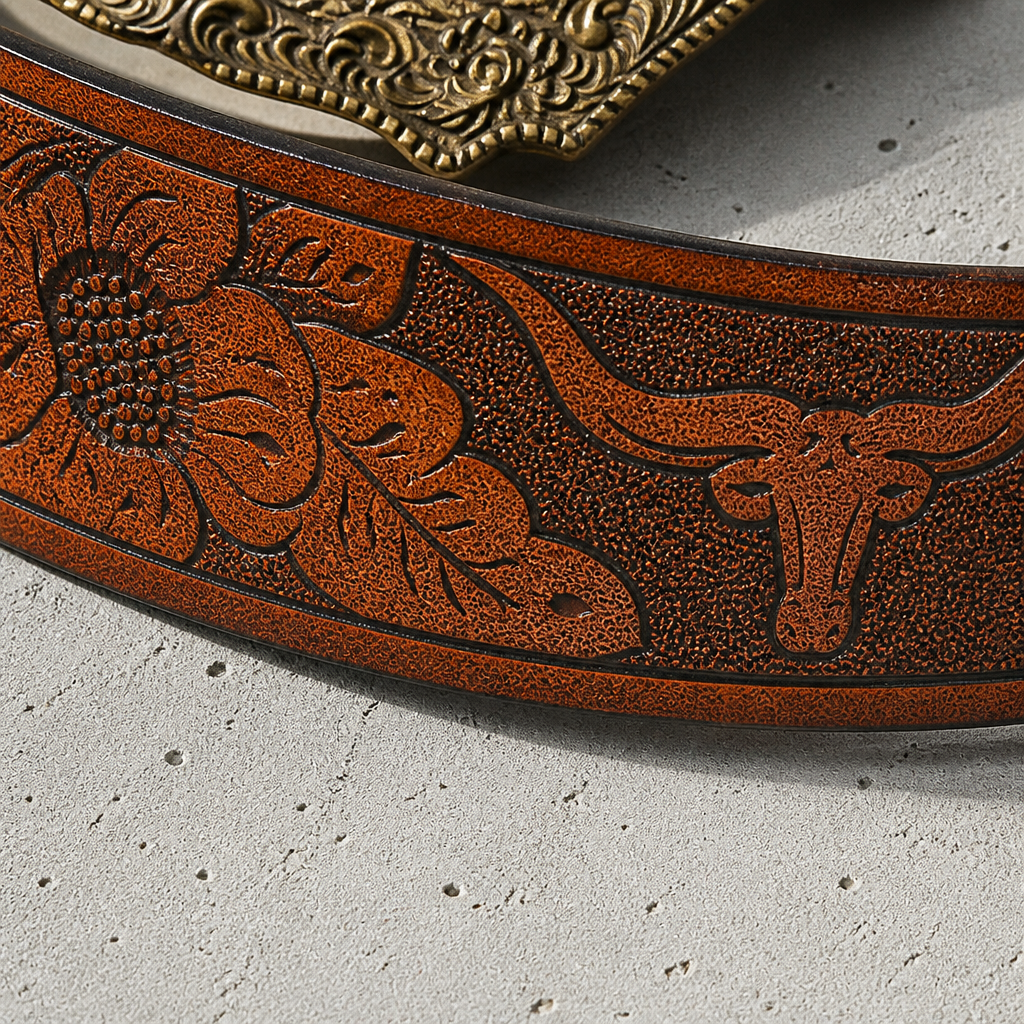 Détail de la sangle marron embossée de fleurs, de feuillages et d'une silhouette de taureau