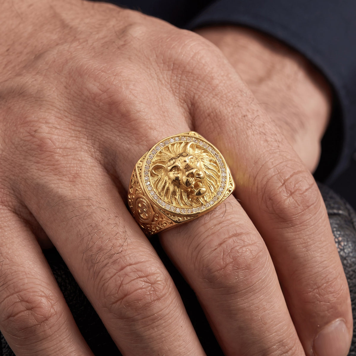 Grosse chevalière homme or lion portée en gros plan, taille réelle sur le doigt