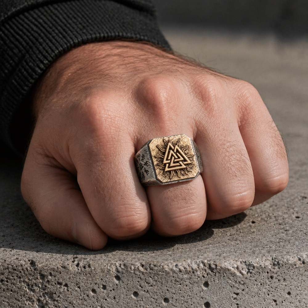 Chevalière viking Valknut portée à l'annulaire, poing fermé posé sur du béton