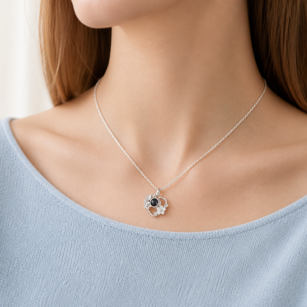 Collier photo cœur fleuri argent porté par une femme