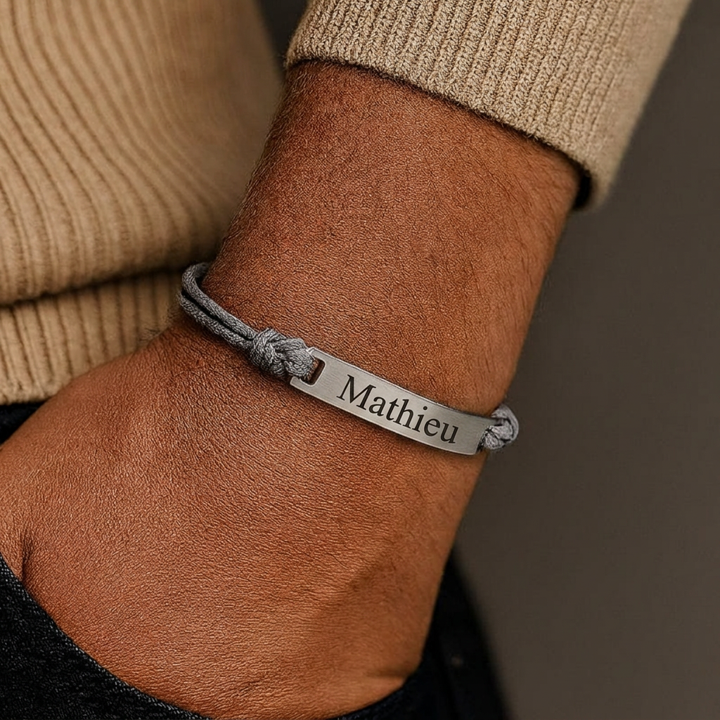 Cordon bracelet homme gris porté au poignet, barrette argent gravée d'un prénom