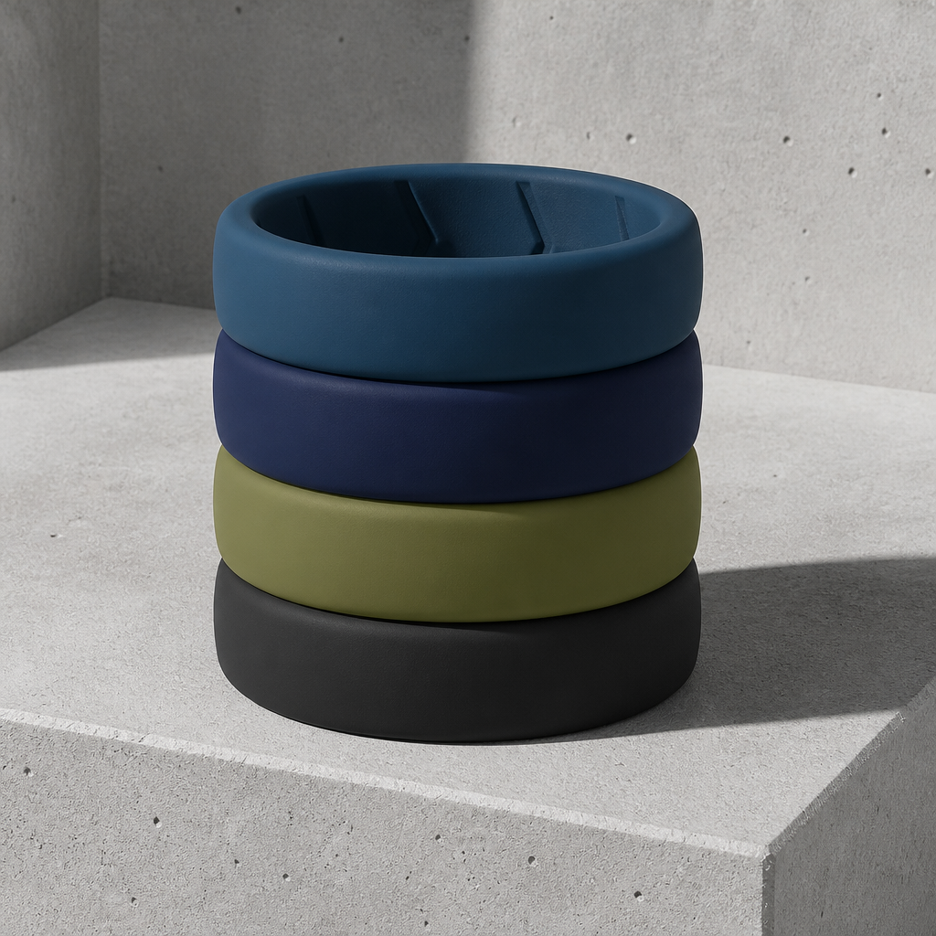 Les quatre bagues en silicone du lot empilées sur un bloc de béton