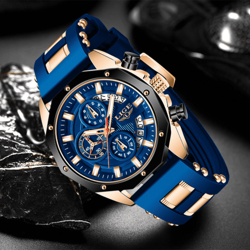 Montre bracelet silicone homme bleue et or rose posée sur un morceau de charbon