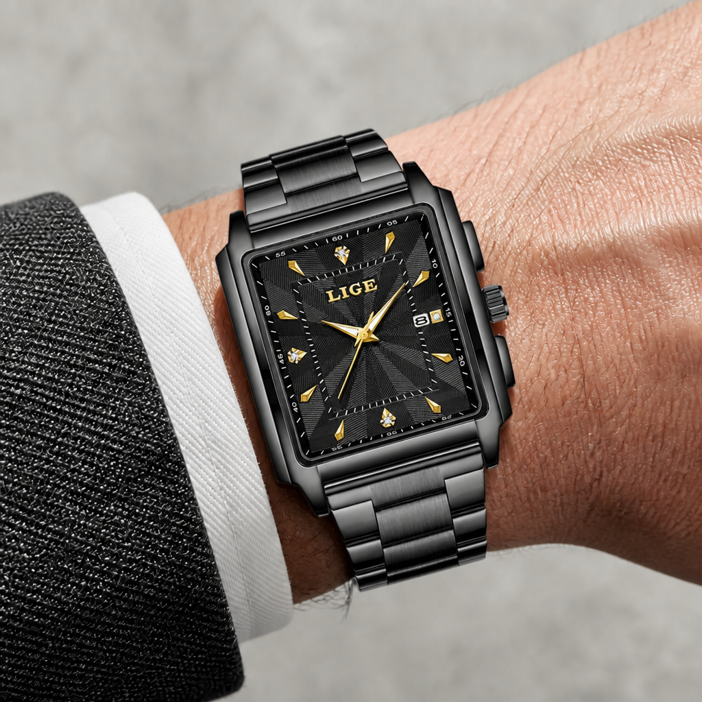 Montre carrée noire à index dorés portée au poignet sous une manchette de chemise