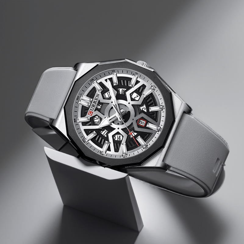 Montre homme sportive grise posée de trois quarts, bracelet silicone déroulé