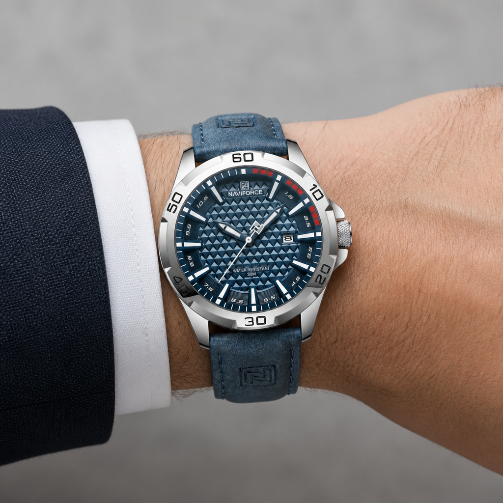 Montre homme tendance à gros cadran bleu portée au poignet sous une manchette de chemise
