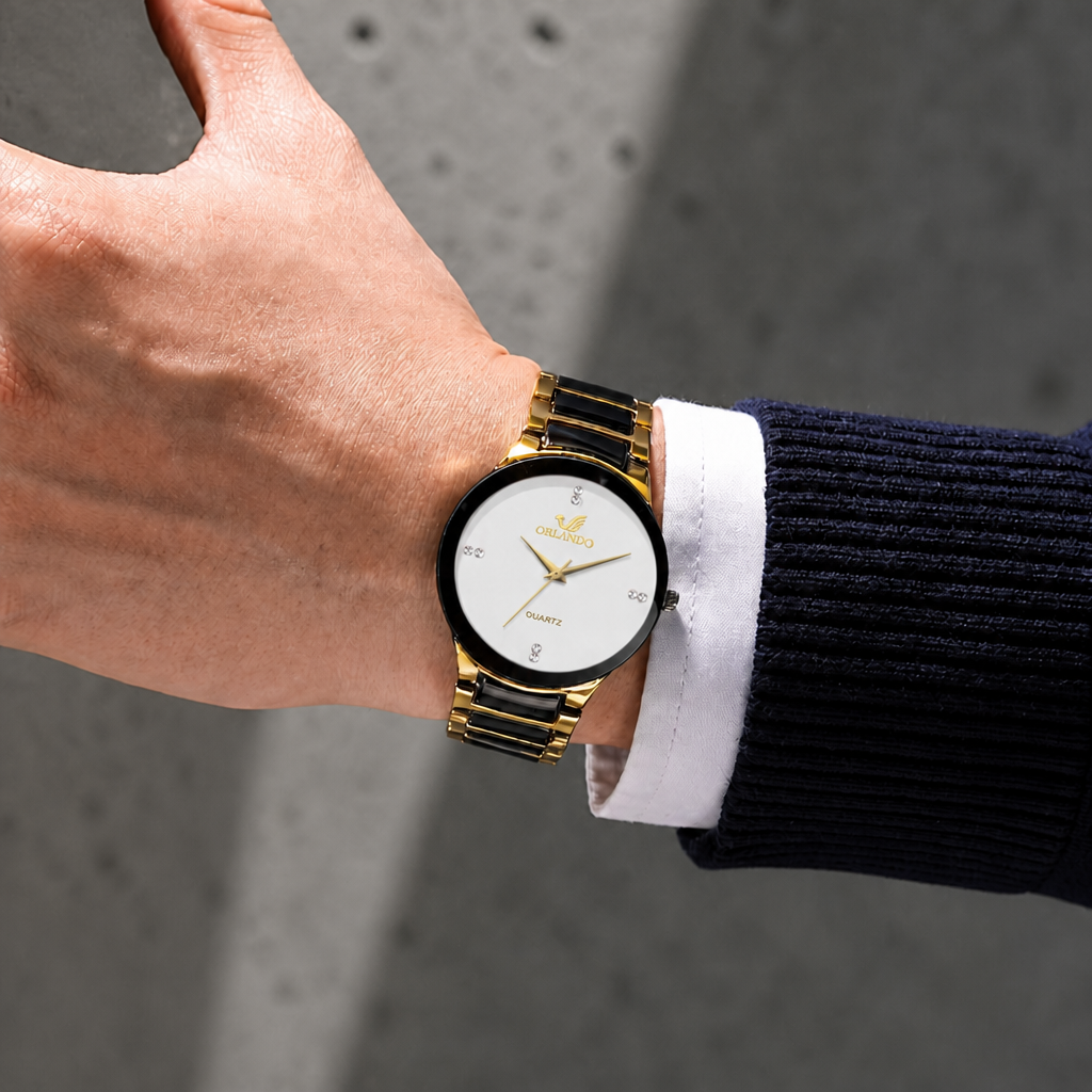 Montre noir et or homme portée au poignet, cadran blanc